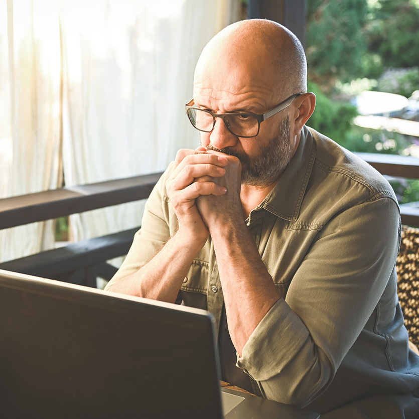 Mann vor Laptop mit verzweifeltem Gesichtsausdruck